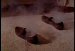 Shoes on carpeted floor with smoke coming out of them