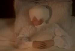 A young boy in a bed with bandages wrapped around his head and eyes