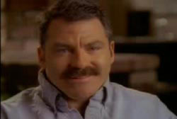 Smiling James Van Praagh in a blue shirt with a mustache