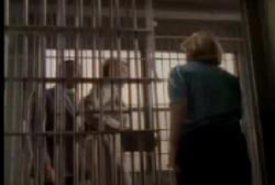 Etta being escorted to a jail cell by police
