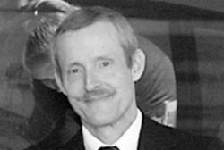 Bruce Ivins with a mustache in a suit and tie