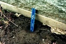 A blue ruler leaning against a gravestone
