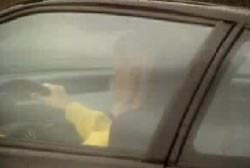 Woman in yellow shirt driving a car