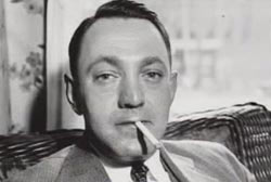 Dutch Schultz in a suit and tie smoking a cigarette