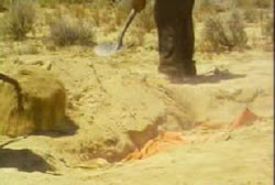 Leon using a shovel to dig s a hole in the new mexico desert