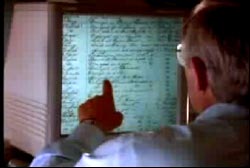 A man pointing at a computer screen with scans of shipwreck documents