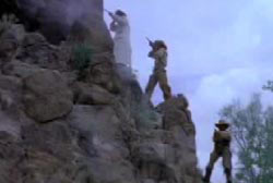 Three gunmen on the side of a ridge shoot at smugglers with rifles
