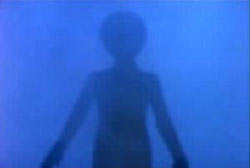 A humanoid figure with a large head emerging from blue smoke (An Alien)