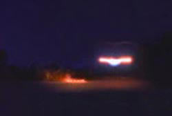 A UFO with a large beam of red and blue light hovering in the sky of Ontario Canada