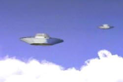 Two disk shaped UFOs soaring above the clouds