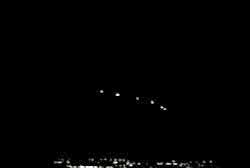 A frame from home video footage of the same arrangment of yellow lights in the sky
