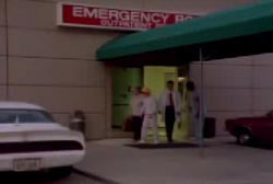 Betty being escorted out of an emergency room by a doctor and nurse