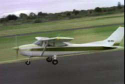 A Cessna 182 airplane lifting off from a landing strip