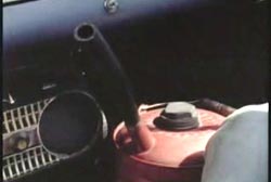 A canister of gass on the passenger side floor of a car