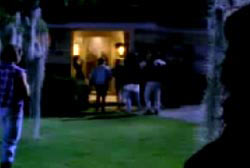 A group of young people walking up to a house with the lights on
