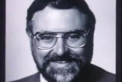 Smiling Chuck Morgan with glasses and suit