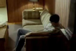Danny sitting on the end of couch in a living room
