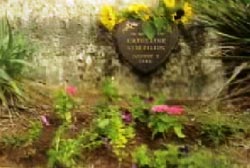 A plaque surrounded by foliage and flowers commemorating the life of Katherine