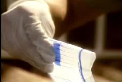 Investigator wearing rubber gloves examining a bag containing traces of cocain