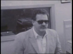 Security camera footage of a caucasian man with sunglasses and a mustache