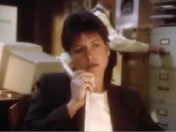 Detective Teresa Martin sitting in a police station having a conversation on the phone