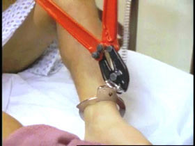 Man using pliers to break prison ankle cuffs