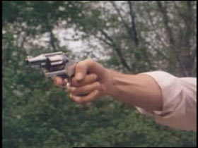 Arm extended aiming a silver revolver at "Carol" 