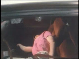 the unconcious body of Carol laying across the front seats of her car after being shot
