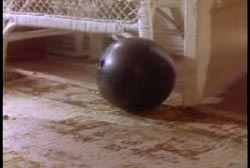 A black bowling ball on the living room floor