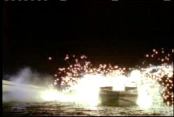 A speedboat crashing into a small boat sending sparks flying