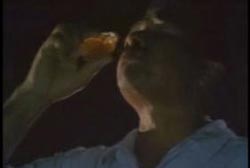 A man takes a sip of a mysterious orange liquid