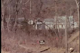 A farm in the woods with a no trespassing sign in the front